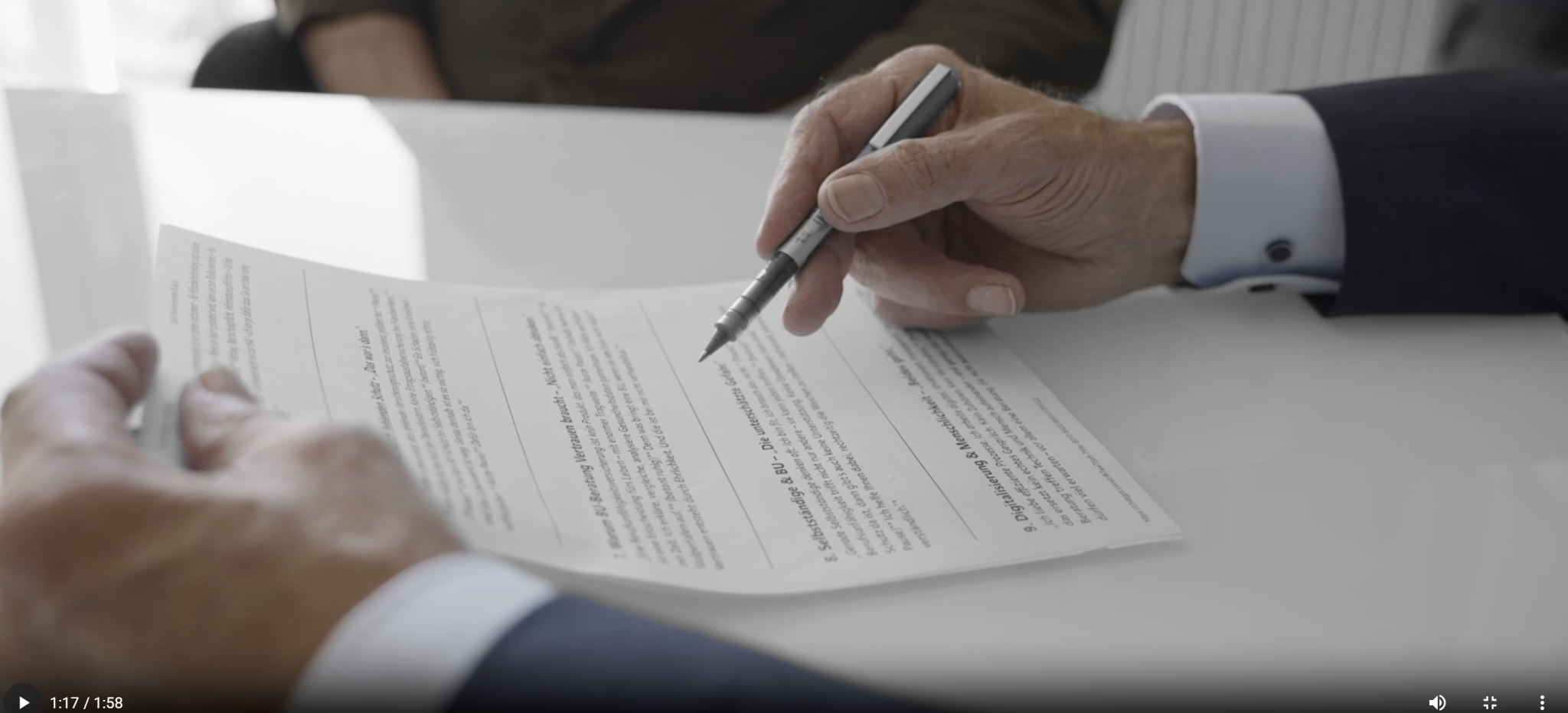 Foto Beratung am Schreibtisch und Aufzeigen Vertragsklauseln